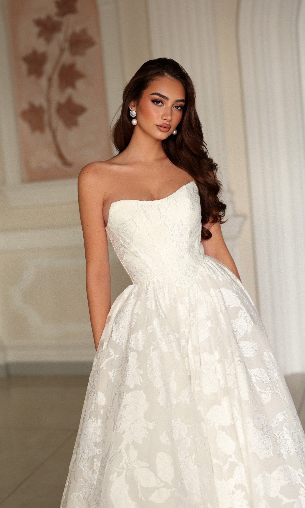 Tina Holly TW627 strapless white wedding dress featuring a fitted bodice and a full, floral organza jacquard skirt.
