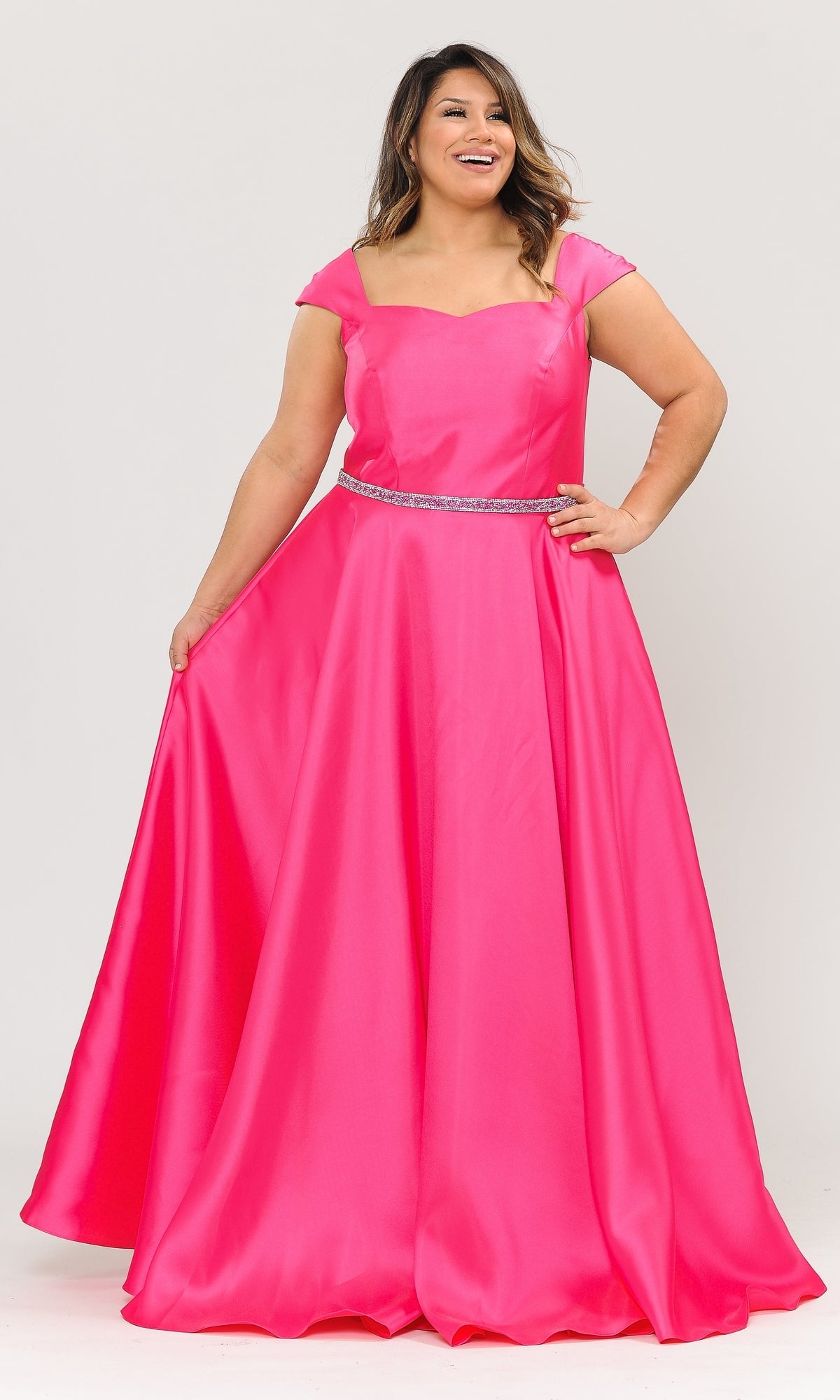 A woman models the Plus-Size Cap-Sleeve Long Prom Dress W1104 in fuchsia, featuring a beaded belt and A-line skirt, as she poses holding out one side of the skirt.