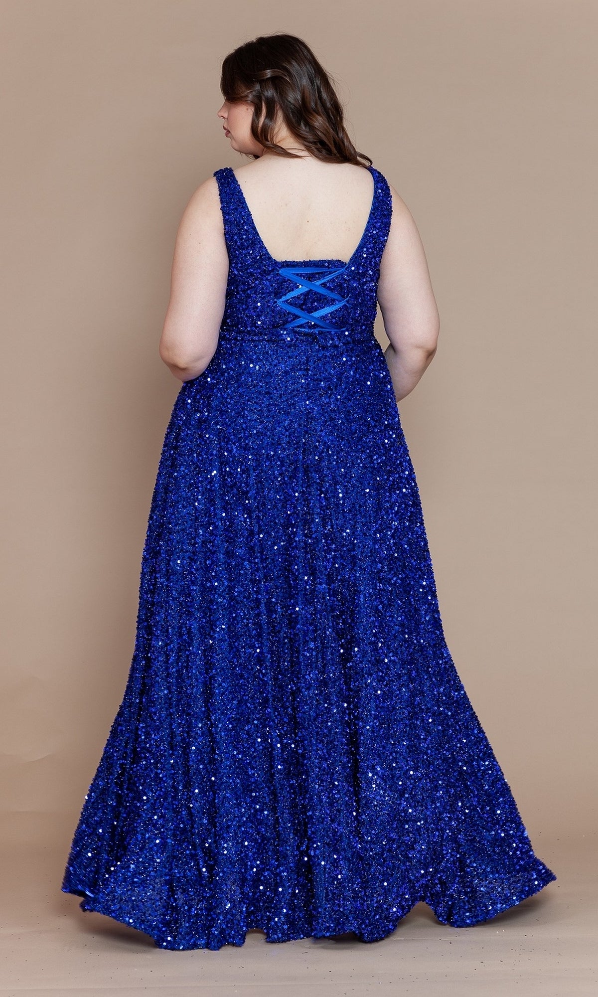 A woman wearing the Plus Long Sequin Prom Dress with Underskirt W1128, featuring a sleeveless design and corset-style lace-up back, stands facing away from the camera against a plain beige background.
