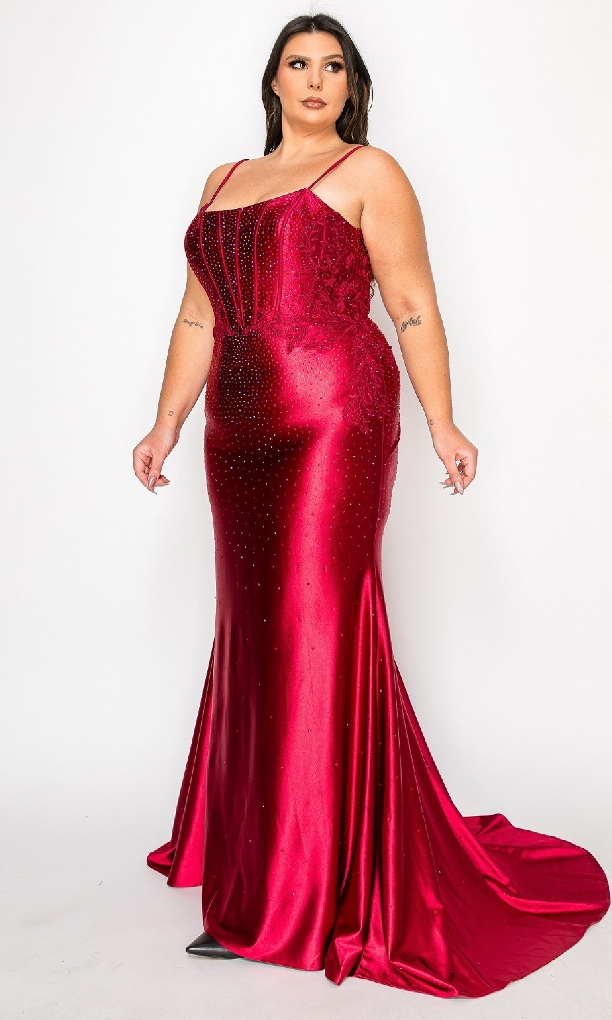 A woman wears the Plus-Size Tight Beaded Prom Dress: PolyUSA W1164, a fitted, floor-length red satin gown with thin straps and subtle beading, posing against a plain white background.