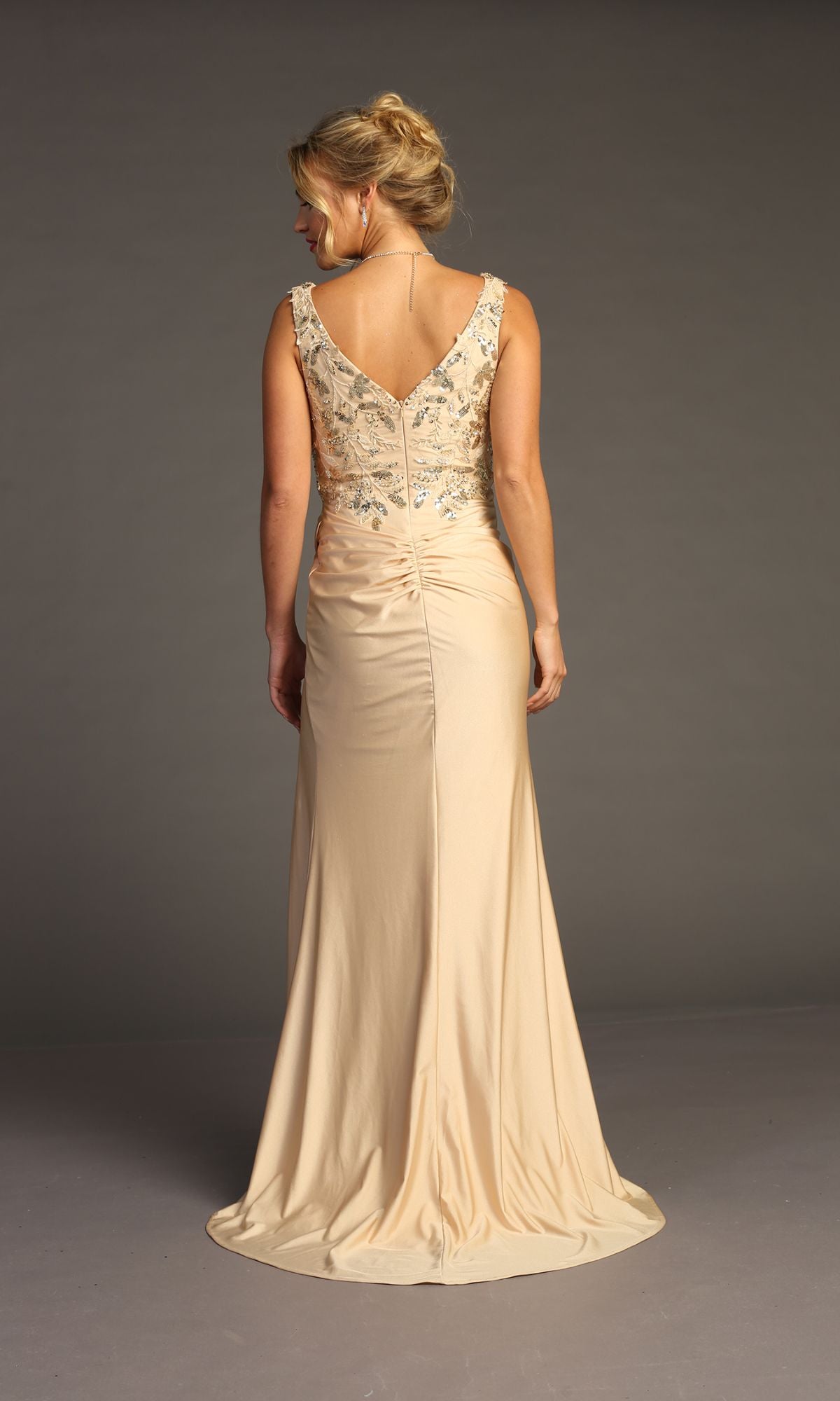 A woman faces away, wearing the Sequin-Bodice Long Prom Dress (Chicas YG5032), a sleeveless floor-length gown featuring decorative beading on the upper back and shoulders, set against a plain gray background.