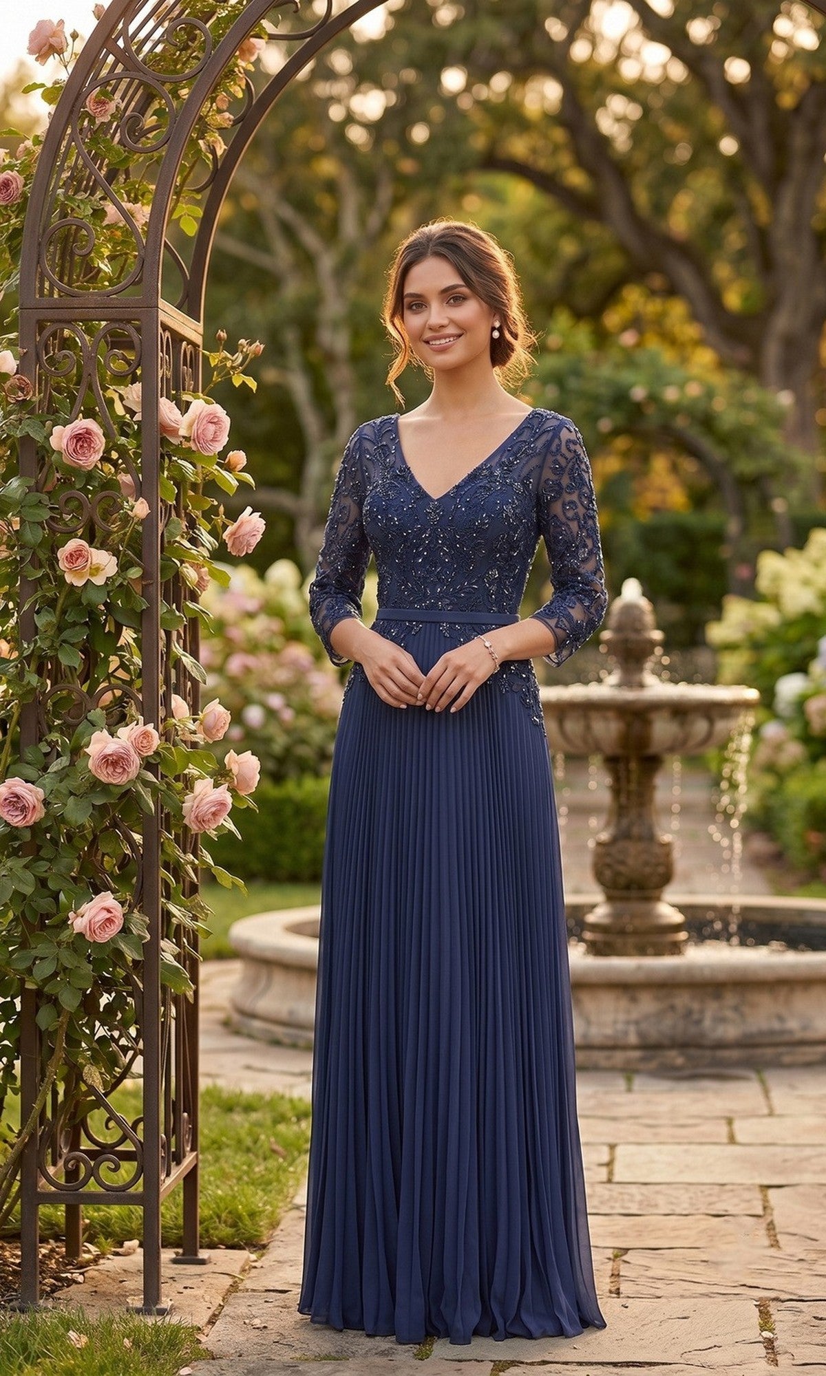A woman in the Long Formal Dress: Chicas YG5038, a navy gown with lace sleeves and an embroidered bodice, stands on a stone path in a garden by a fountain and a rose-covered archway.