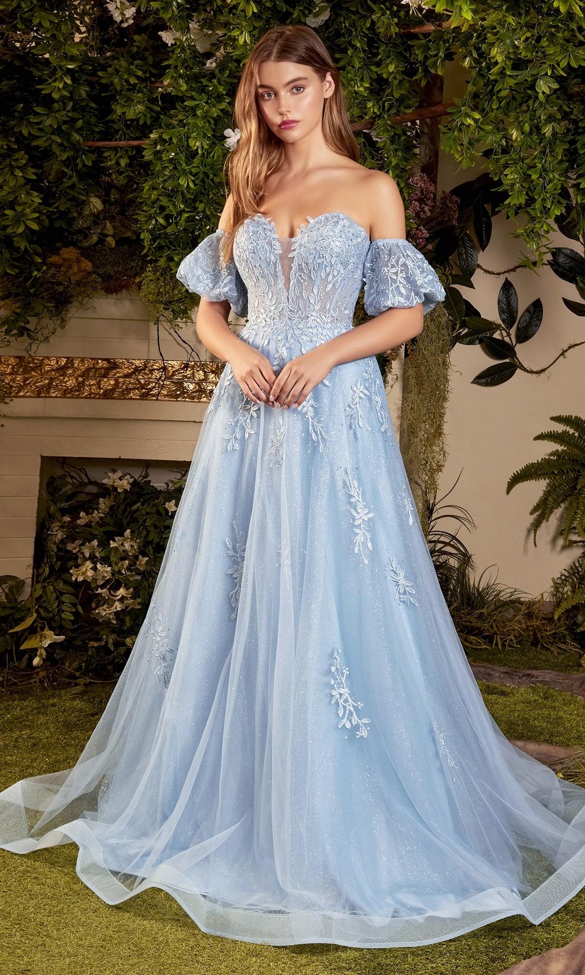 A woman stands outdoors surrounded by greenery, wearing the Strapless Puff-Sleeve Long Prom Ball Gown A1046 with sparkling embroidery and tulle layers.
