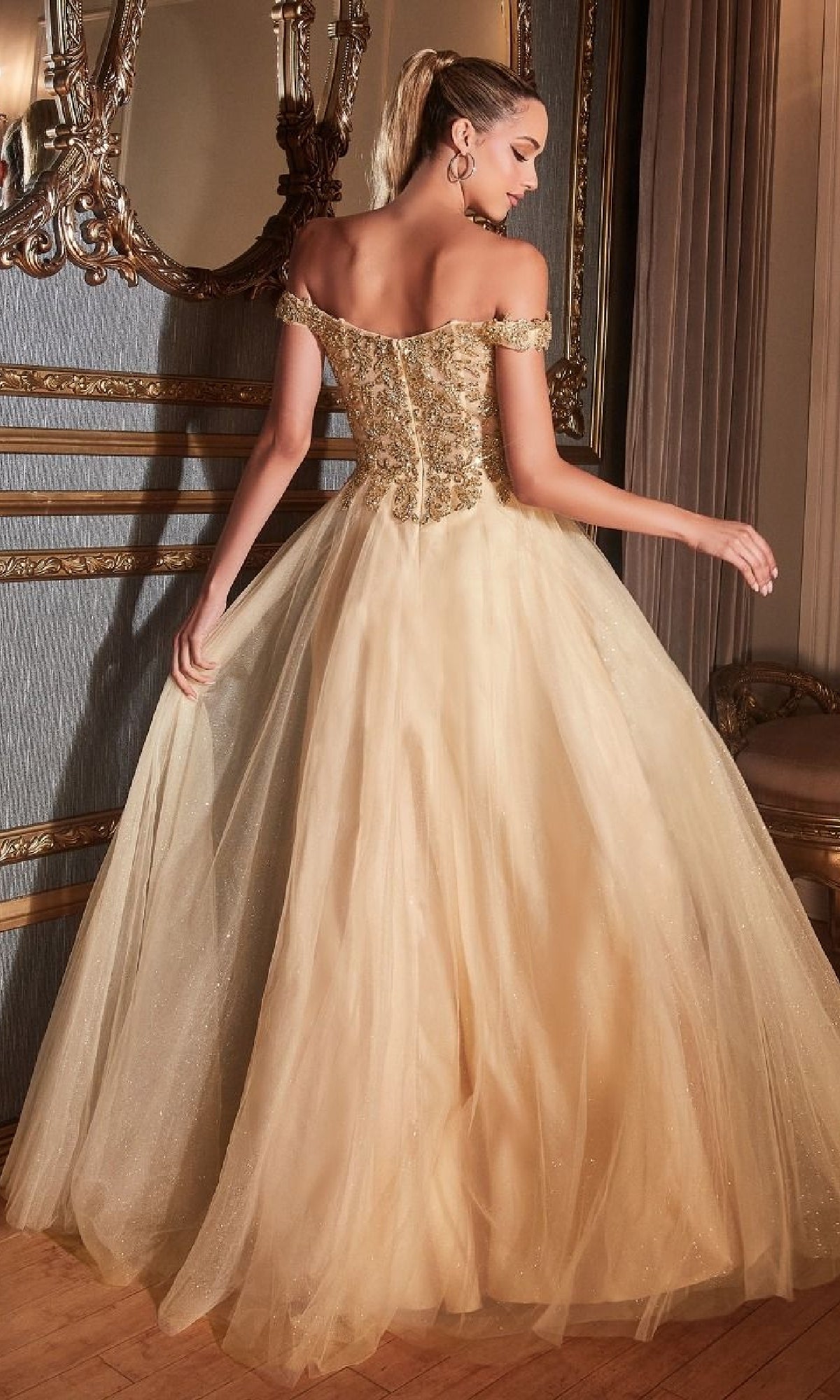 A woman wearing the Beaded-Bodice Long Prom Dress: Ladivine CD0177 stands indoors, facing away, framed by ornate decor and a mirror in the background.