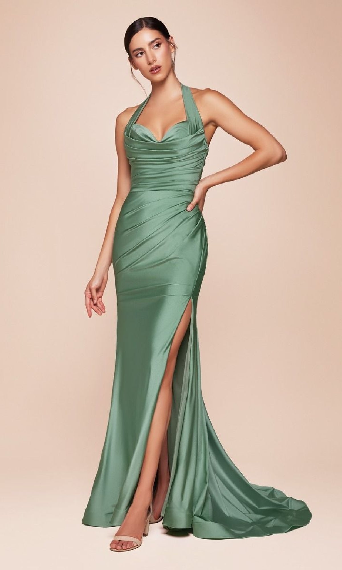 A woman poses in the Classic Long Halter Prom Dress: CLCD796—a sage green satin, sleeveless gown under $150 with a ruched bodice, high slit, and halter neckline—standing against a neutral background.