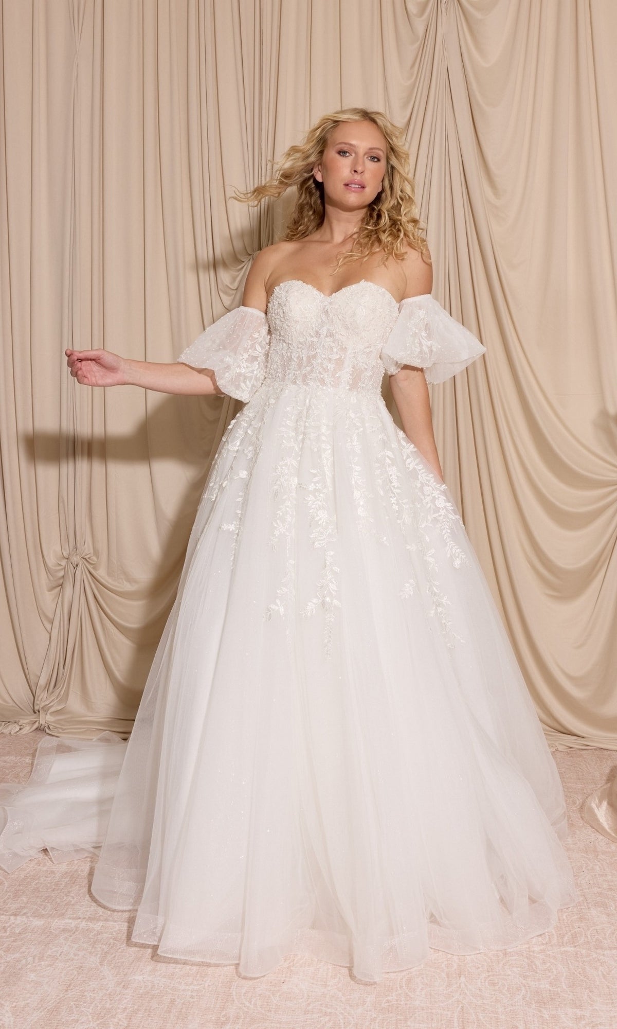 Woman in the Long Wedding Dress: Eureka EK155 with detachable puff sleeves, standing before beige draped fabric.