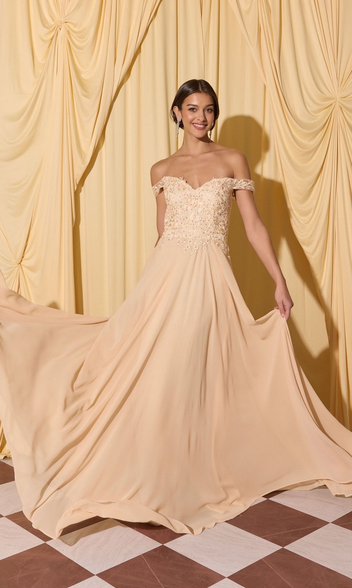 Woman in the Long Prom Dress: Eureka EK211, featuring an off-the-shoulder lace applique bodice and flowing skirt, stands on a checkered floor before yellow draped curtains.