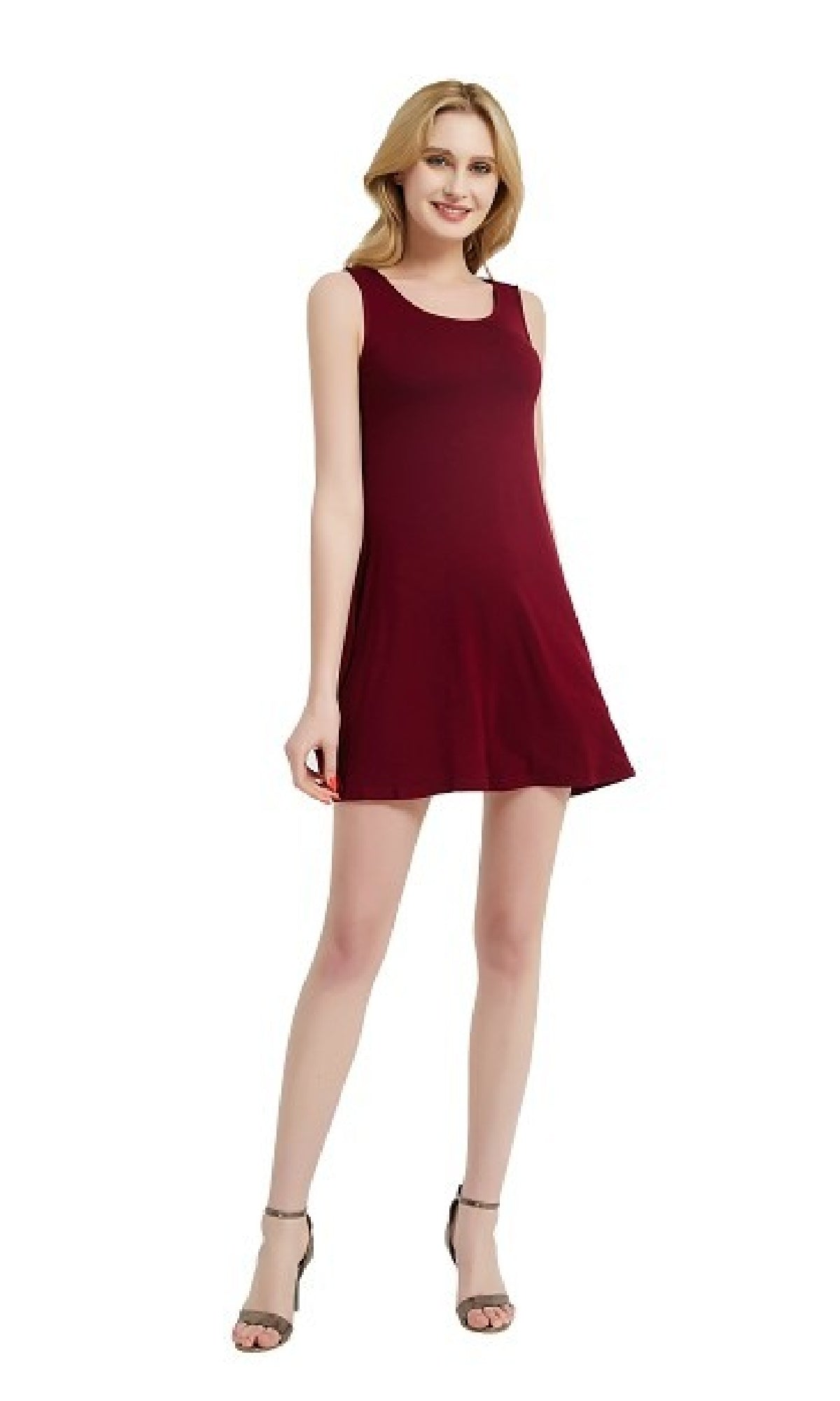 A woman wears a Sleeveless Casual Short T-Shirt Dress with Pockets and gray high-heeled sandals, standing against a white background.