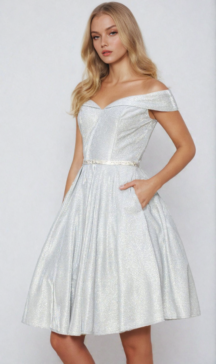 A woman models the Off-Shoulder Short Glitter Homecoming Dress 8012J, featuring a silver fitted bodice and flared knee-length skirt, posing stylishly with one hand in her pocket against a plain background.