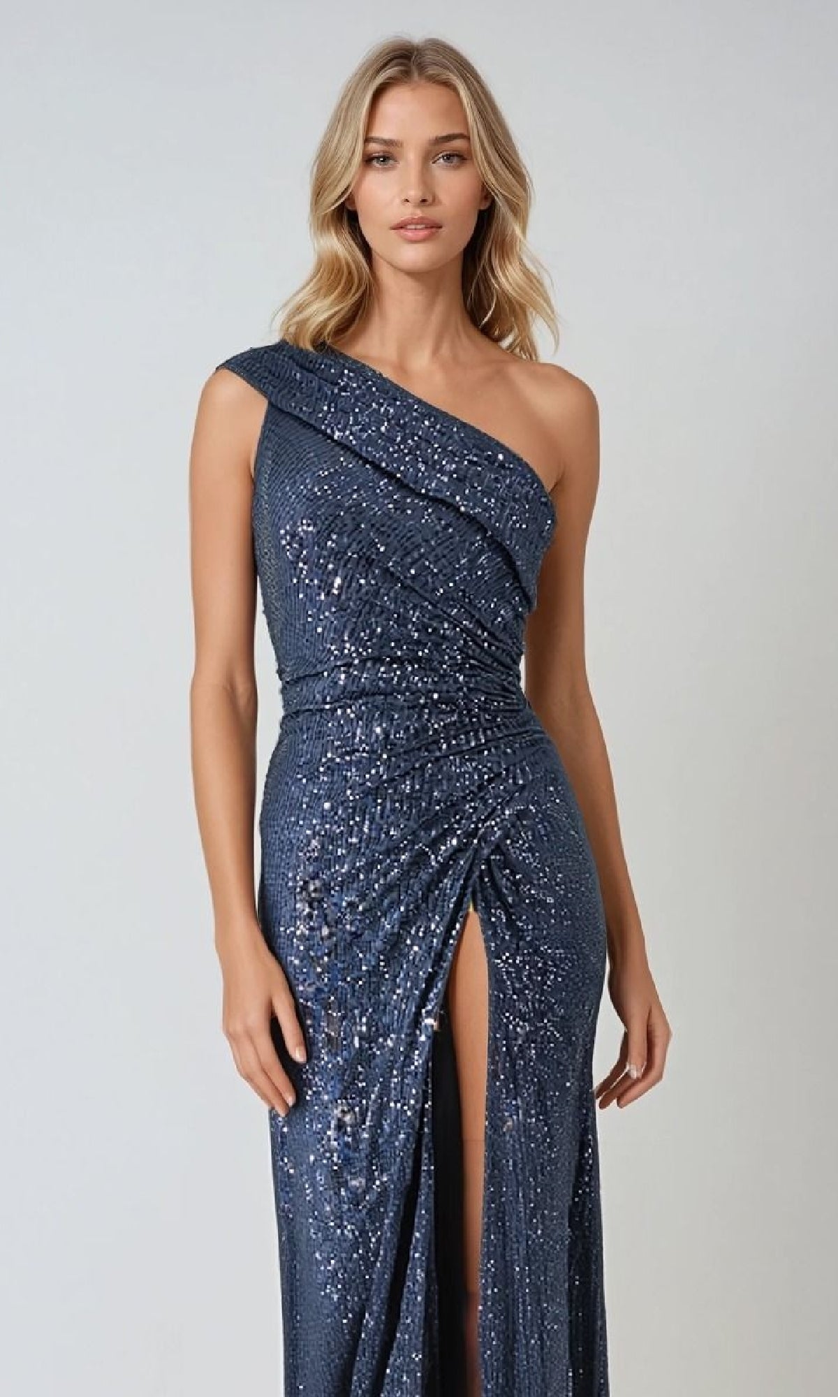 A woman models the Amoris T806: a dark blue, one-shoulder long sequin prom dress with a thigh-high slit, standing against a plain light background—a dazzling choice for special occasions.