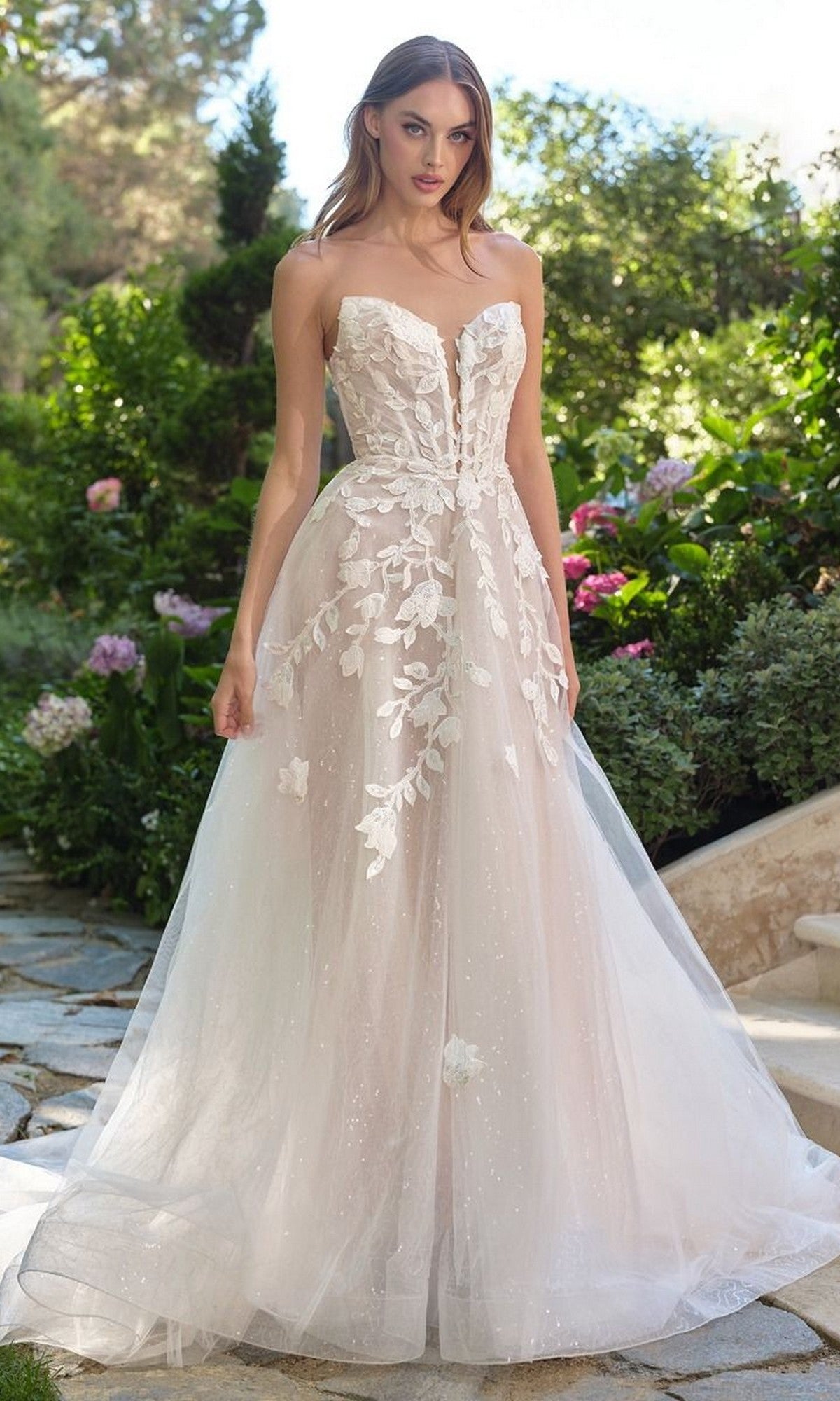 A woman wearing the Andrea and Leo WL070 long wedding dress in off white/nude, featuring 3D floral lace appliques and an elegant A-line tulle skirt.