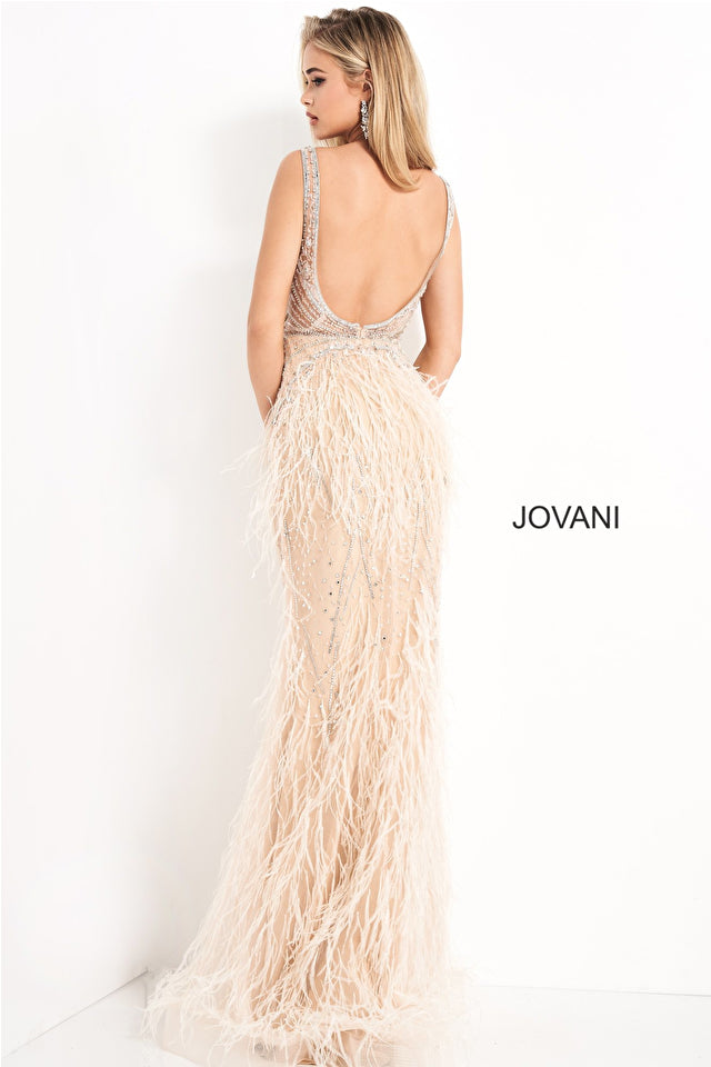 A woman poses in the Jovani Sheer-Bodice Long Prom Dress with Feathers—a sleeveless, floor-length gown with a beaded, backless bodice and feather-embellished skirt.