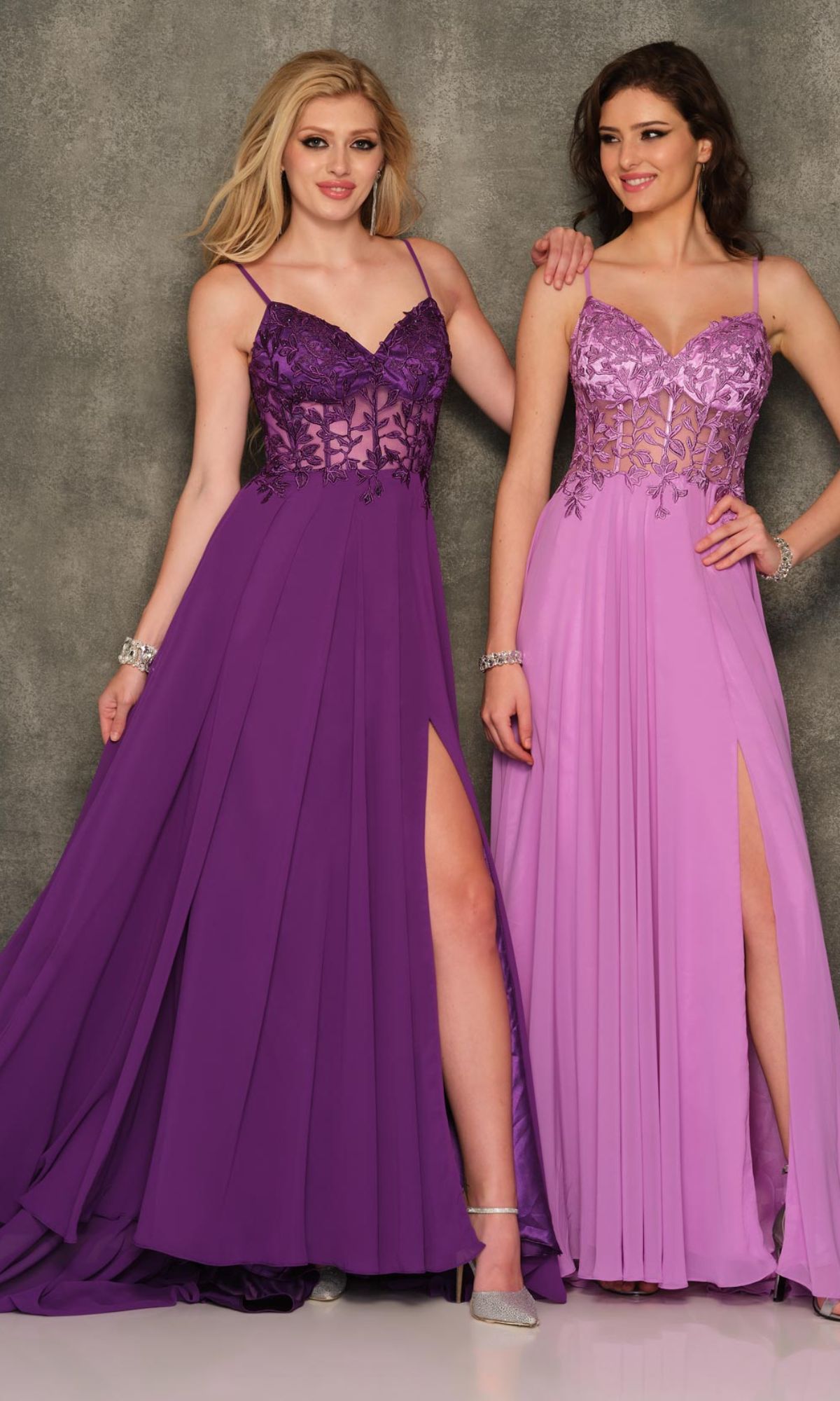 Two women stand side by side in Sheer-Bodice Dave & Johnny Long Prom Dresses featuring lace bodices and thigh-high slits; one dress is rich purple, the other is light lavender.