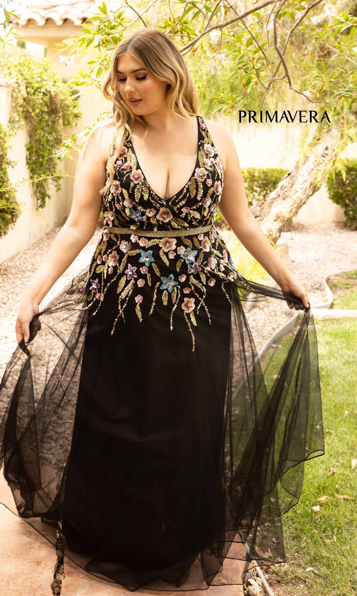 A woman wears the Floral-Beaded Long Black Plus-Size Prom Dress, an elegant evening gown featuring beautiful floral beading.