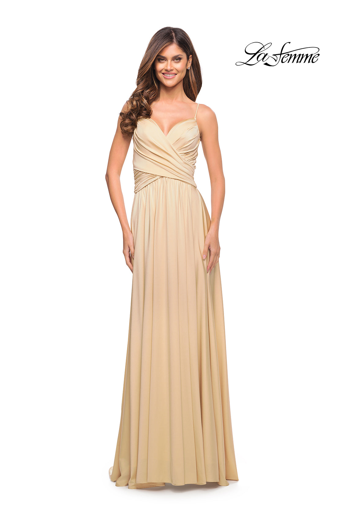 A woman stands smiling in a long, light beige La Femme Simple Elegant Long Formal Prom Dress with thin straps and a ruched bodice. The
