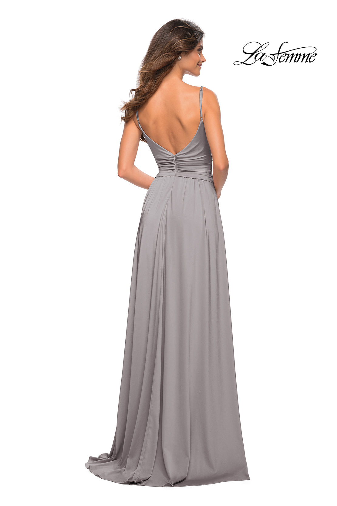 Woman in a floor-length, light gray La Femme Simple Elegant Long Formal Prom Dress with thin straps and open back, standing and facing away.