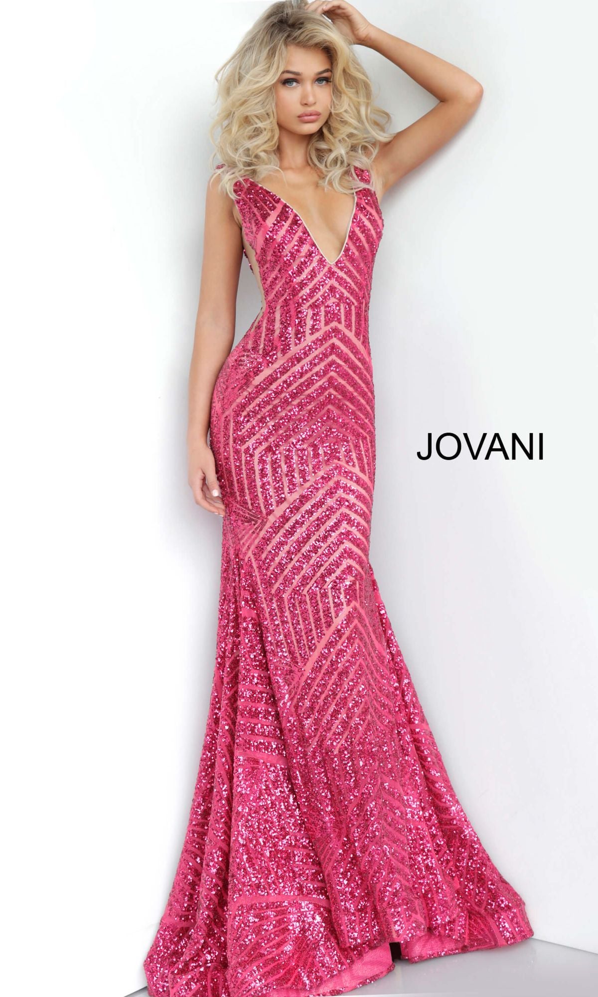 A woman models the Jovani Plus-Size Mermaid Prom Dress with Sequins, a floor-length, sleeveless gown featuring a deep V-neckline, standing against a white background with