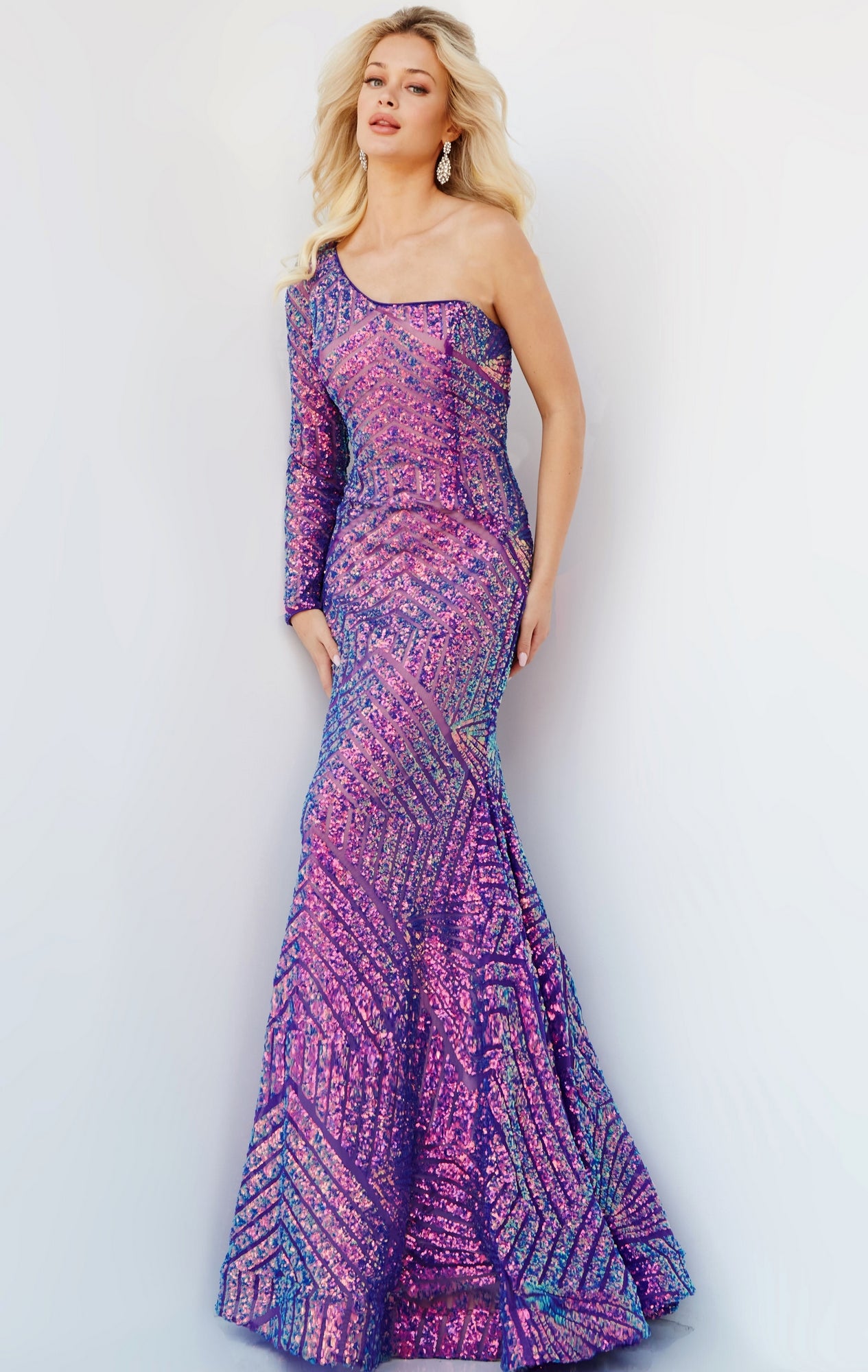 A woman poses in a Jovani Violet Purple Prom Dress with one long sleeve, fitted and floor-length with sequins, against a plain light background.