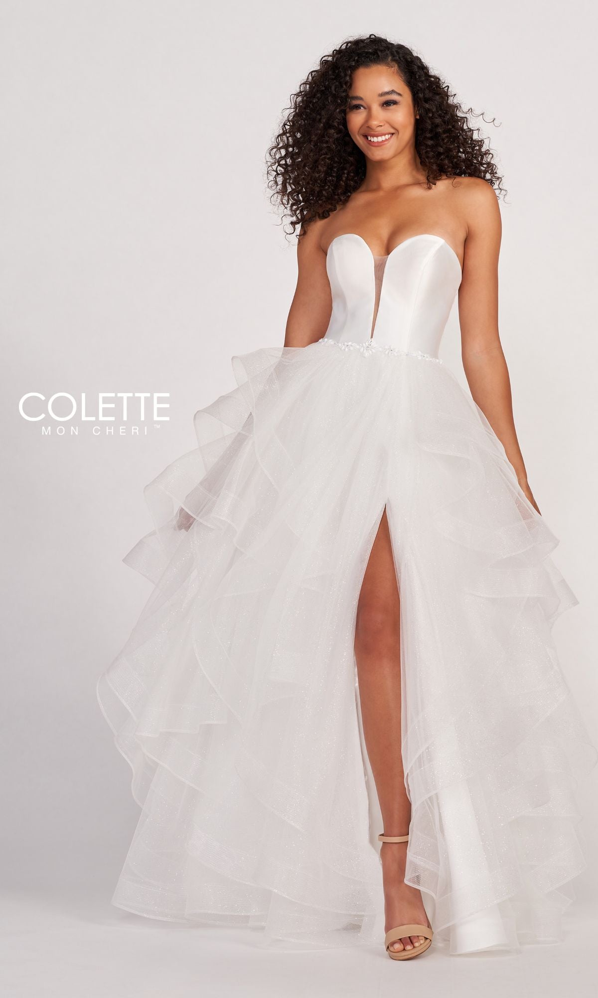 A woman models the Colette Glitter-Tulle Layered Long Prom Ball Gown—a strapless formal dress with a deep neckline, tiered ruffled skirt, and front slit—standing against a plain light background.