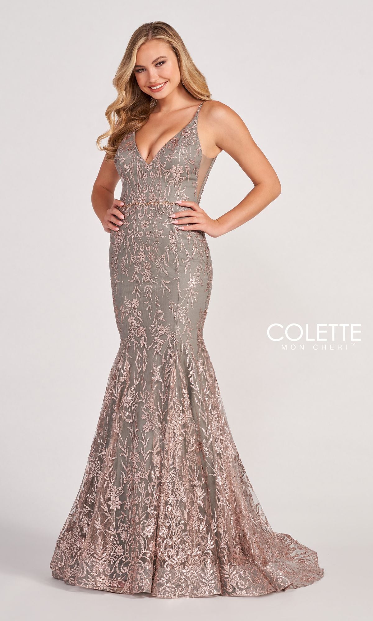 A woman smiles against a light background in the Colette CL2021 Long Mermaid Glitter Prom Dress, a sleeveless, floor-length gown with intricate metallic embroidery.