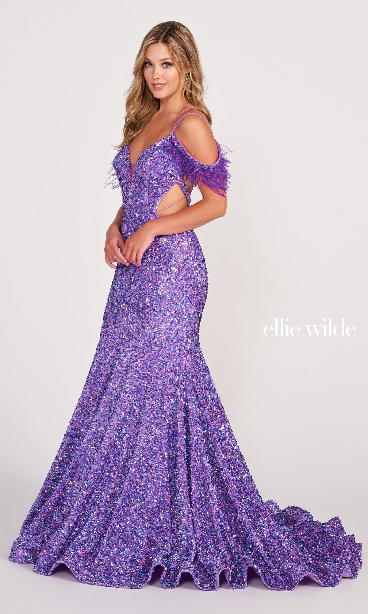Woman wearing the Long Sequin Cut-Out Prom Dress with Feathers in sparkling purple, featuring feathered straps, poses against a plain white background. The