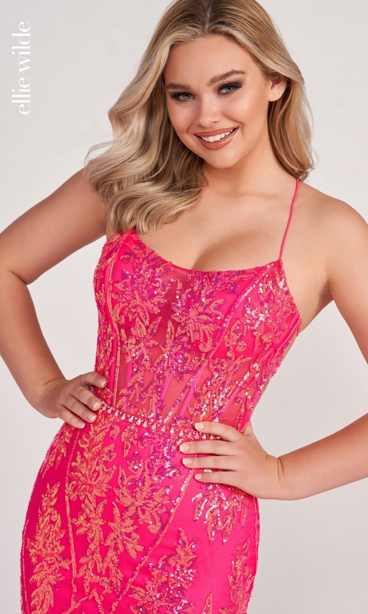 A woman poses in the Sheer-Corset Long Sequin Mermaid Prom Dress, featuring a pink fitted silhouette with gold sequin floral patterns and thin straps, smiling at the camera against a plain background.