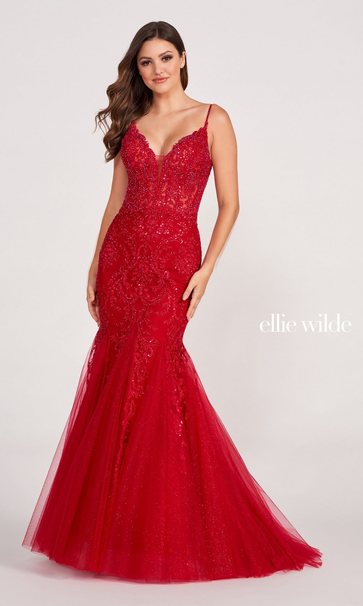 Woman wearing a fitted, floor-length Sheer-Bodice Embroidered Long Mermaid Prom Dress featuring thin straps, lace and sequin details, and a flared tulle skirt;