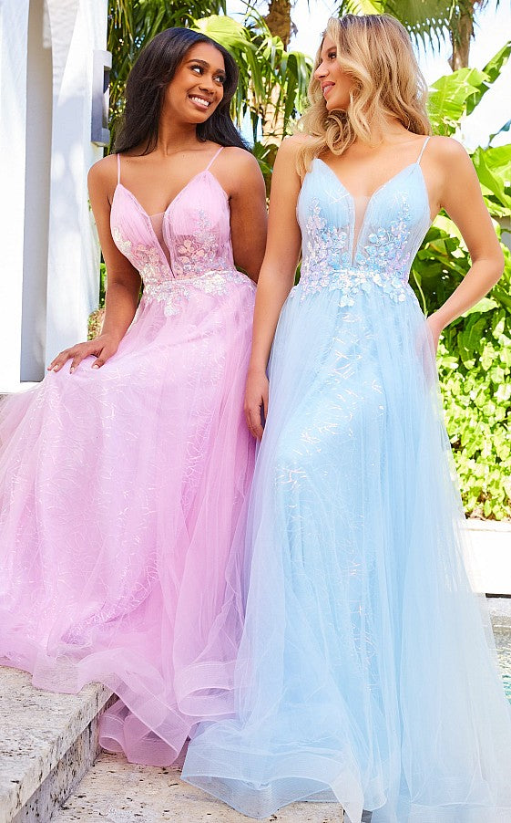 Two women sit outdoors in flowing tulle gowns with floral embroidery and delicate thin straps—one in a light pink dress, the other wearing a Jovani Light Blue Long A-Line Prom Dress.