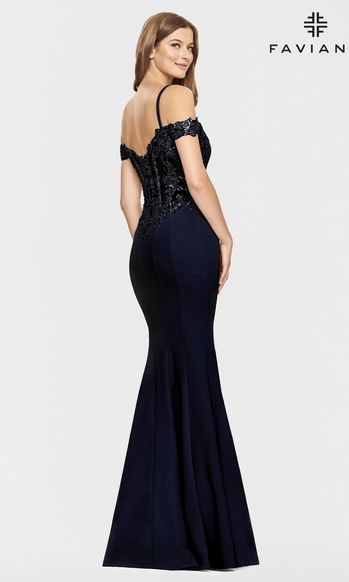 A woman poses against a plain background wearing the Faviana Cold-Shoulder Navy Blue Prom Dress S10866, a fitted mermaid gown with lace detailing. The Faviana logo appears in the top right corner.