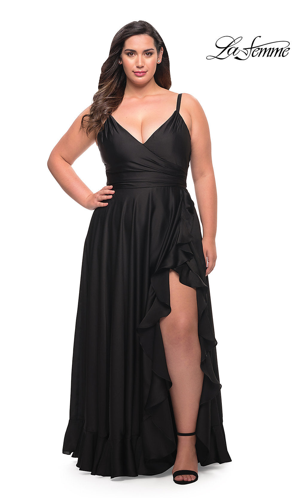 A woman wears the Long Plus-Size La Femme Prom Dress with a deep V-neck, high slit, and ruffle hem in black, standing against a white background. The La Femme logo is shown in the top right corner.