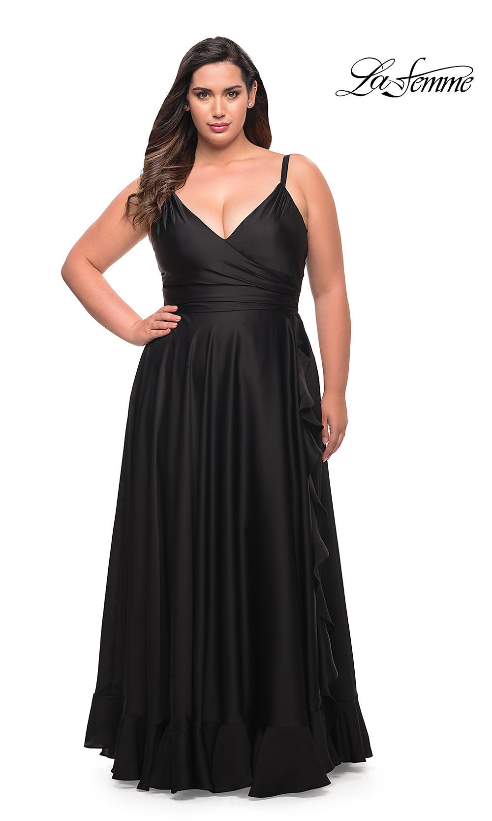 A woman in the Long Plus-Size La Femme Prom Dress, a sleeveless black gown with a wrap-style bodice and ruffle hem, stands against a white background.