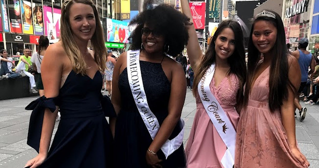 The homecoming queen and three girls in her court celebrating in the city.