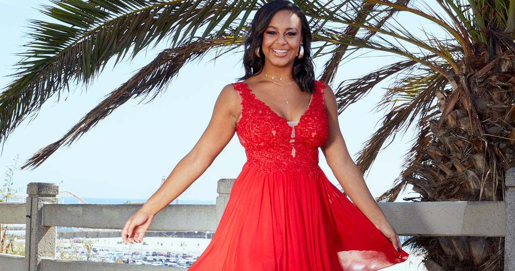 Girl wearing a lace-bodice short red cocktail dress for a summer wedding.