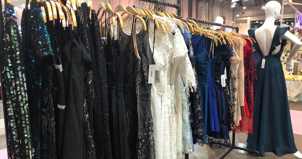 A rack of short homecoming dresses in a variety of colors, fabrics, and styles.