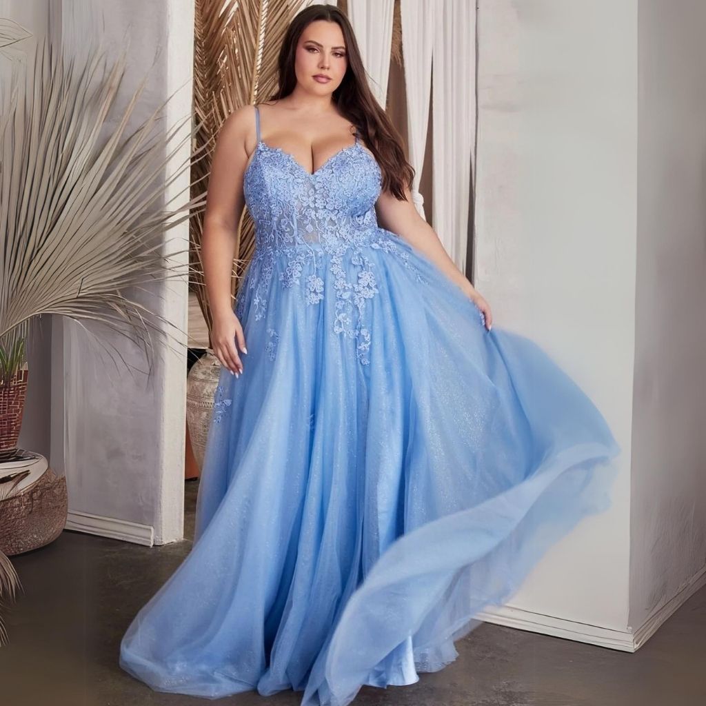 Wearing a light blue sheer corset plus-size ball gown prom dress, a woman swishes the glittering skirt on one side.