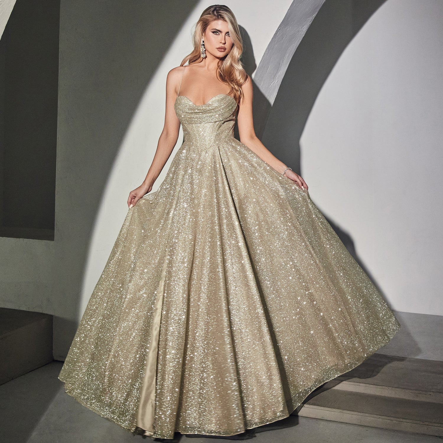 Image of a woman with blonde hair wearing a long metallic glitter gold prom dress.