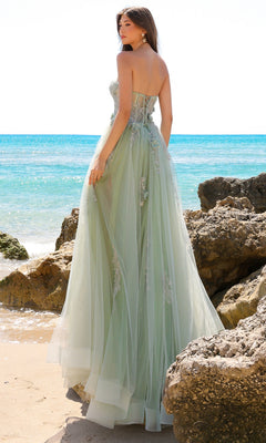 A woman in the Strapless Sheer-Corset Long Tulle Prom Dress TM1002 stands on a rocky beach, facing the ocean.