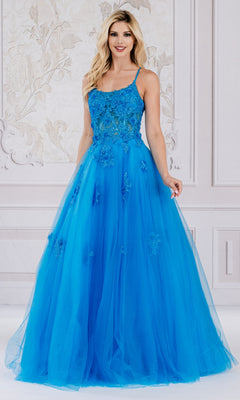 A woman stands in a decorated room wearing the Embroidered-Tulle Long A-Line Prom Ball Gown 7035, featuring a bright blue, floor-length design with floral embellishments.