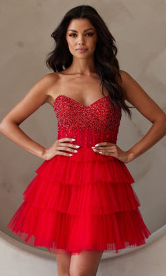 A woman models the Strapless Short Ruffled A-Line Hoco Dress BZ9999S, featuring a beaded bodice and tiered tulle skirt, standing with hands on hips against a neutral background.