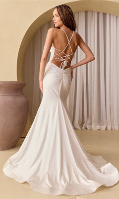 A woman poses in the Open-Back Sparkly Long Beaded Prom Dress 3018, featuring a floor-length backless design with crisscross lace-up straps, in front of an arched curtain and large ceramic vase.