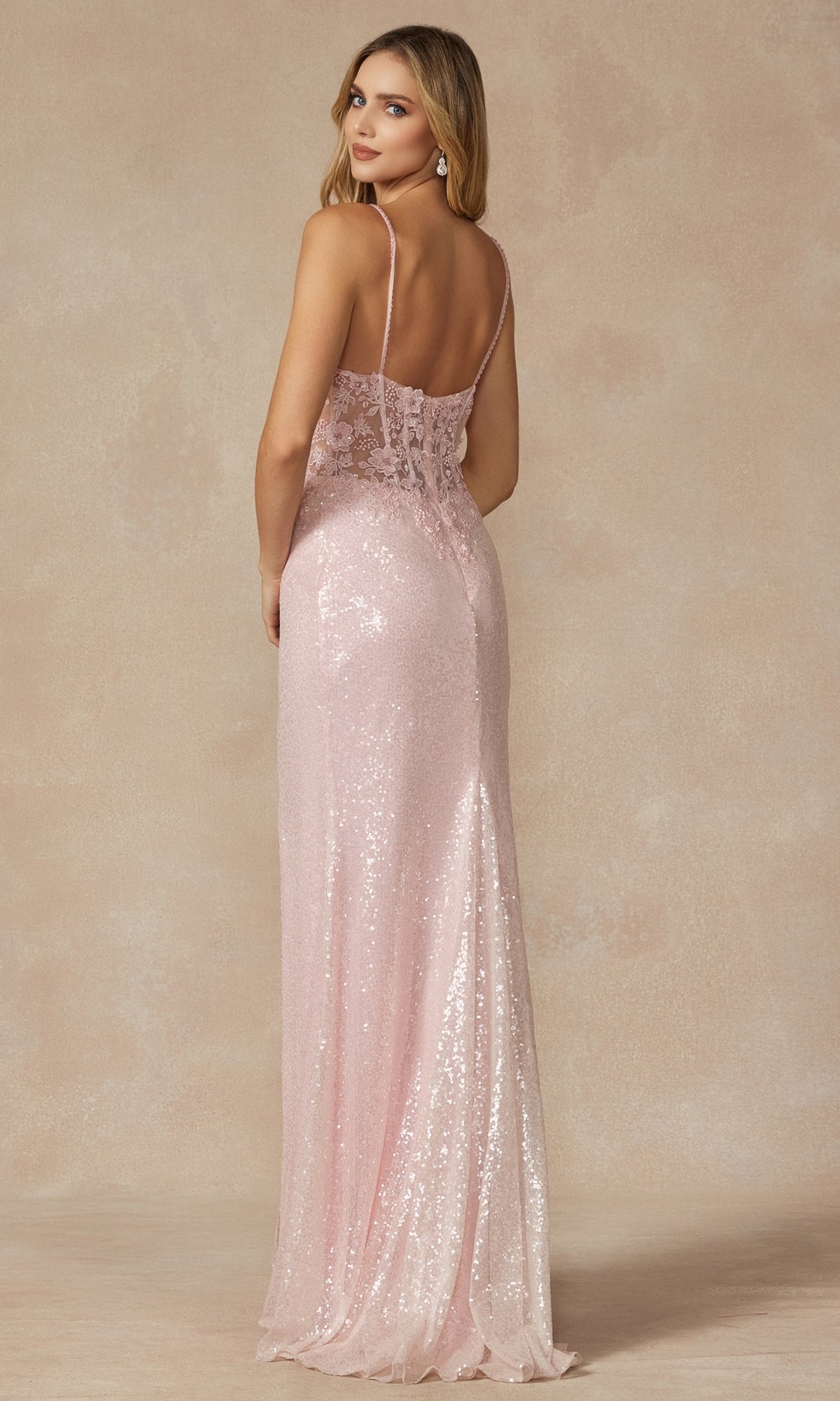 A woman faces away, wearing an Embroidered-Corset Long Sequin Prom Dress 289 in light pink with thin straps and a backless design—a stunning choice for any formal event.