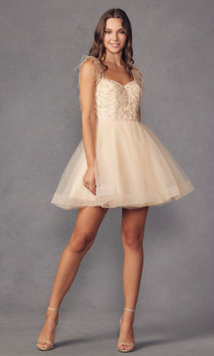 A woman wears the Short Babydoll Homecoming Dress with Feathers 881, featuring a light beige tulle skirt and embroidered sweetheart bodice, paired with nude heels against a plain gray background.