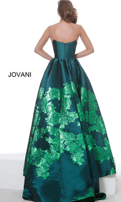 A woman faces away wearing the Jovani Strapless Floral Long Prom Ball Gown 02038—a floor-length teal gown with shiny green floral patterns. "Jovani" is visible on the left side.