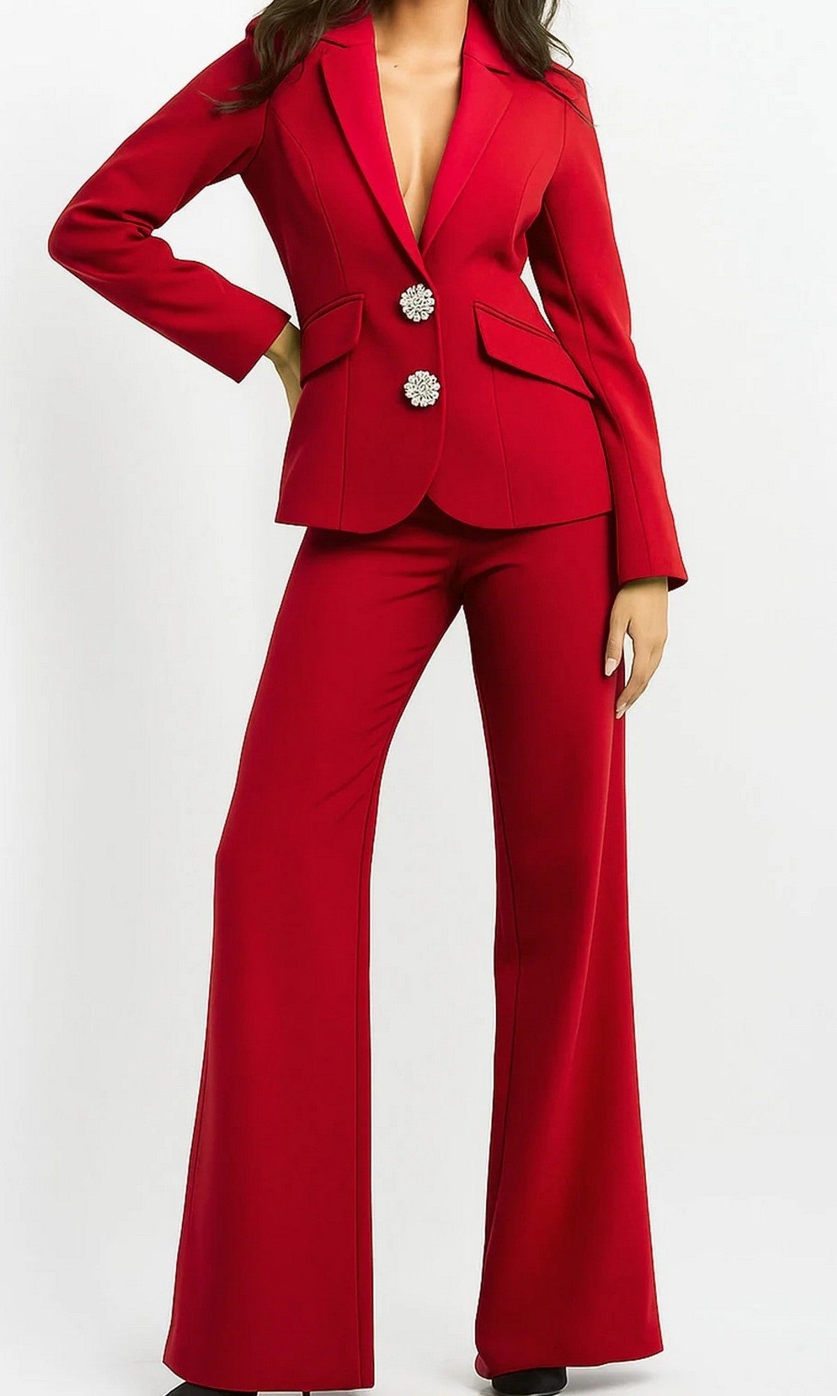 A person poses against a plain white background wearing the Jovani 02637, a red long jumpsuit with wide-leg trousers and a blazer-style top adorned with two large decorative buttons.