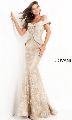 A woman poses elegantly against a white wall in the Jovani 02762 long formal dress, featuring an off-shoulder mermaid silhouette in shimmering gold brocade. The word “JOVANI” appears in black text on the right.