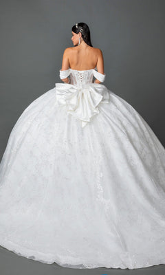 A woman faces away from the camera, wearing the Long Wedding Dress 0322 by Dancing Queen—an off-the-shoulder ballgown with a lace-up back, a large satin bow, and a full, embellished skirt—set against a plain gray background.