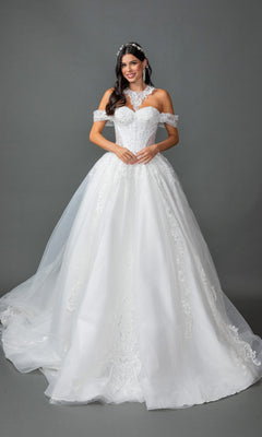 A woman wearing the Long Wedding Dress: Dancing Queen 0324 in off white, an elegant off-the-shoulder lace ballgown featuring delicate lace details and a long train, complemented by statement earrings and a jeweled headpiece, stands against a plain gray background.