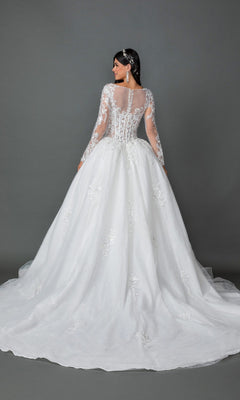 A woman faces away, wearing the Long Wedding Dress 0325 by Dancing Queen—a long-sleeved white gown embellished with delicate floral lace appliques, featuring a full A-line skirt and train—set against a plain gray background.
