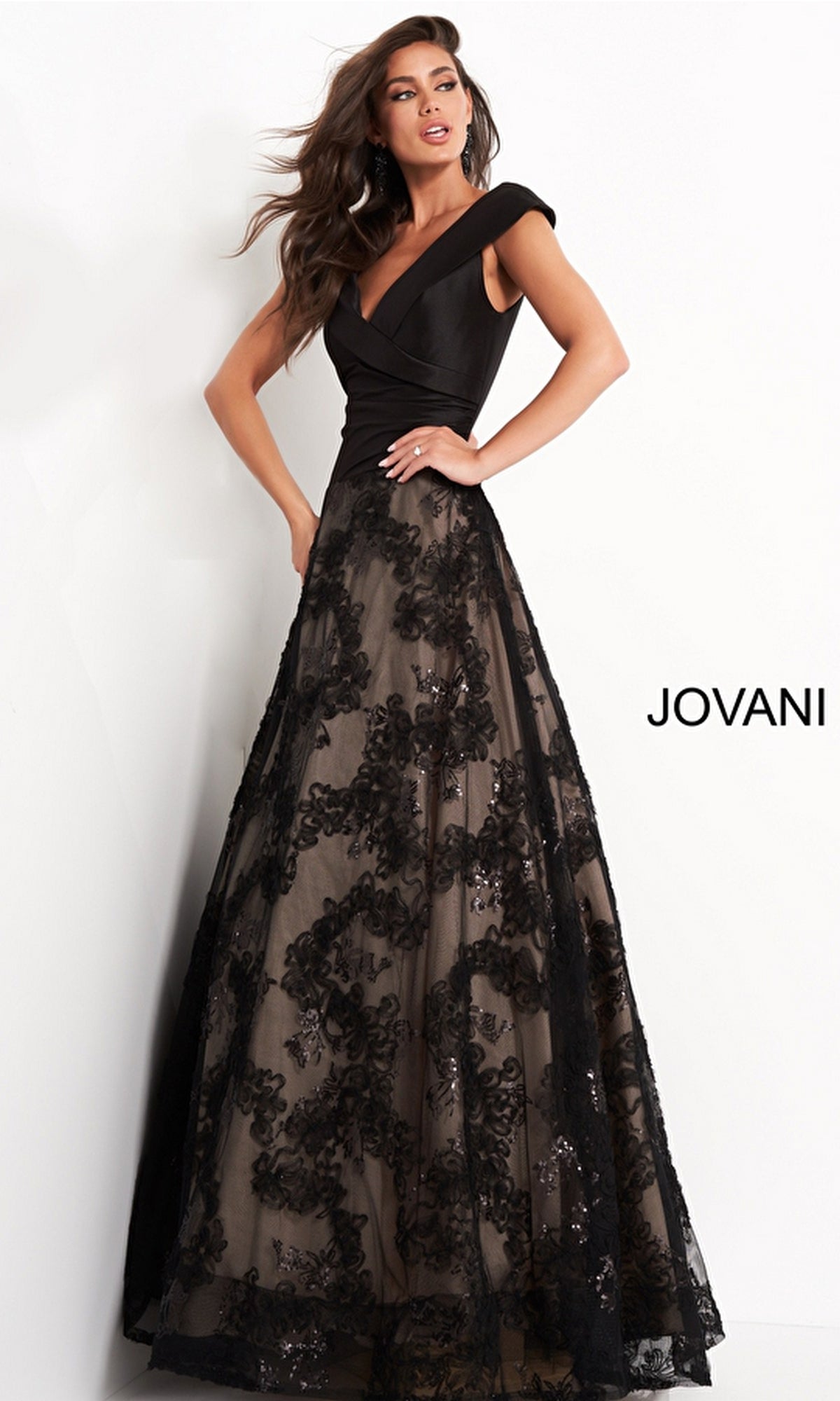 A woman poses in the Jovani Mikado-Bodice Long Black Prom Dress 03330, featuring a fitted satin bodice, lace overlay skirt, cap sleeves, and floral pattern. The word 