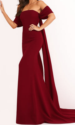 A woman wearing the Long Prom Dress by Jovani 04350 in burgundy, featuring an elegant, strapless, floor-length design with a fitted silhouette and draped fabric detail.